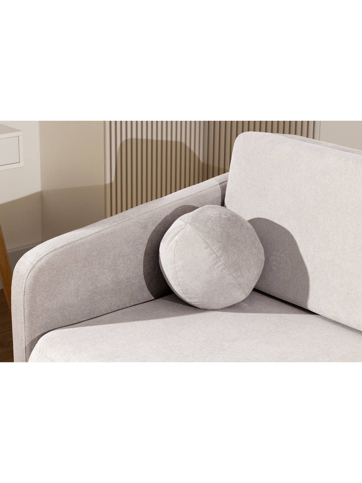 Sofa Zeldia 135 w beżowym kolorze z funkcją spania i okrągłą poduszką